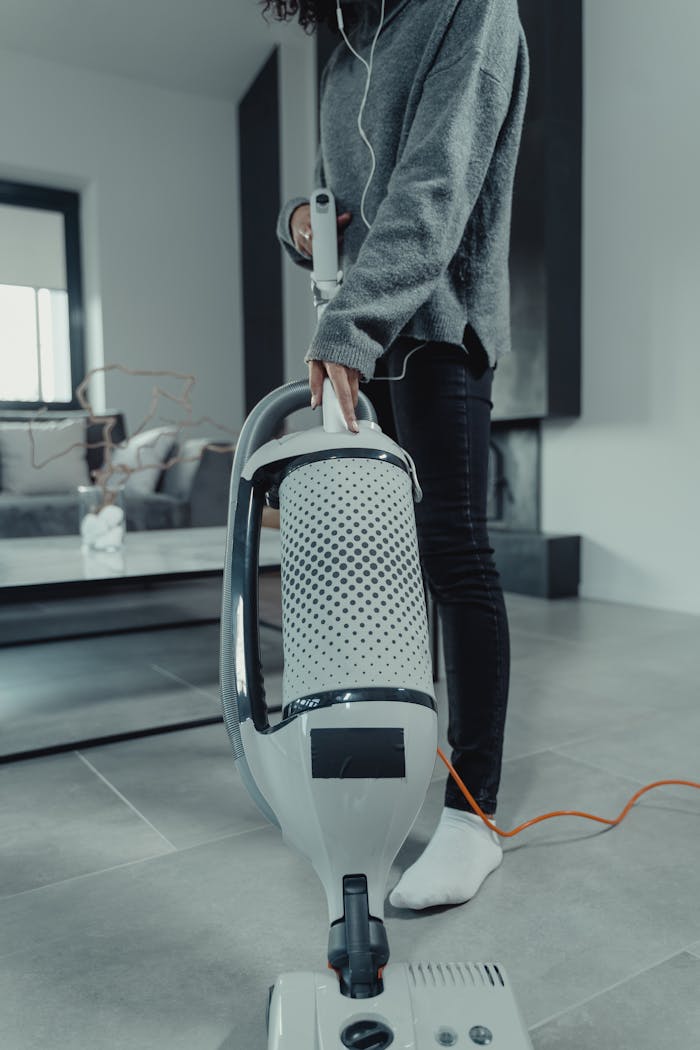 Focused shot of a woman vacuuming a stylish living room, emphasizing cleanliness.
